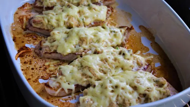 Mit Champignons und goldbraunem Käse überbackenes Putenschnitzel mit knusprigen Pommes frites