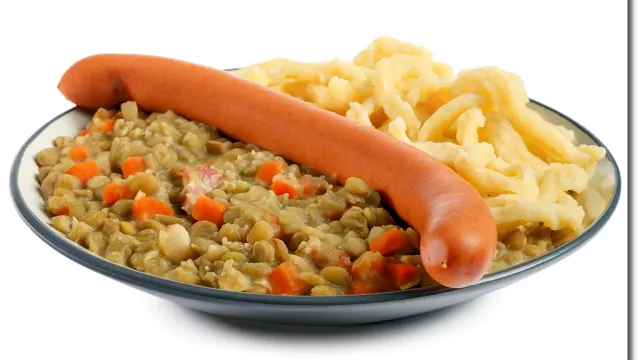Spätzle mit braunen Linsen, Gemüse und gebratenen Bauchspeckstücken auf einem Teller