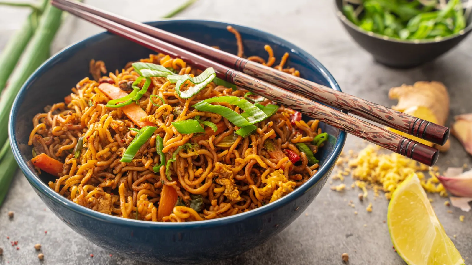 Gebratene asiatische Mie-Nudeln mit Paprika, Brokkoli, Möhren, Pilzen und Frühlingszwiebeln in einer Schale