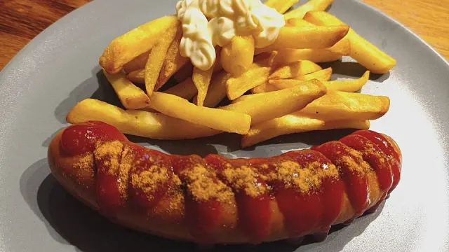 Currywurst in würziger roter Currysauce mit knusprigen Pommes aus der Heißluftfritteuse