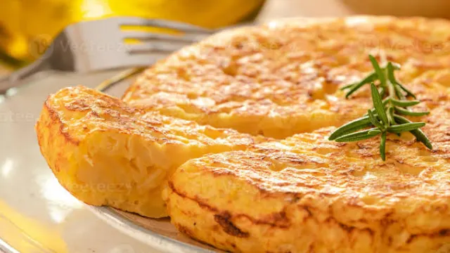 Goldbraune spanische Tortilla mit Kartoffeln und Zwiebeln, in ein dreieckiges Stück geschnitten
