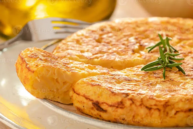 Goldbraune spanische Tortilla mit Kartoffeln und Zwiebeln, in ein dreieckiges Stück geschnitten